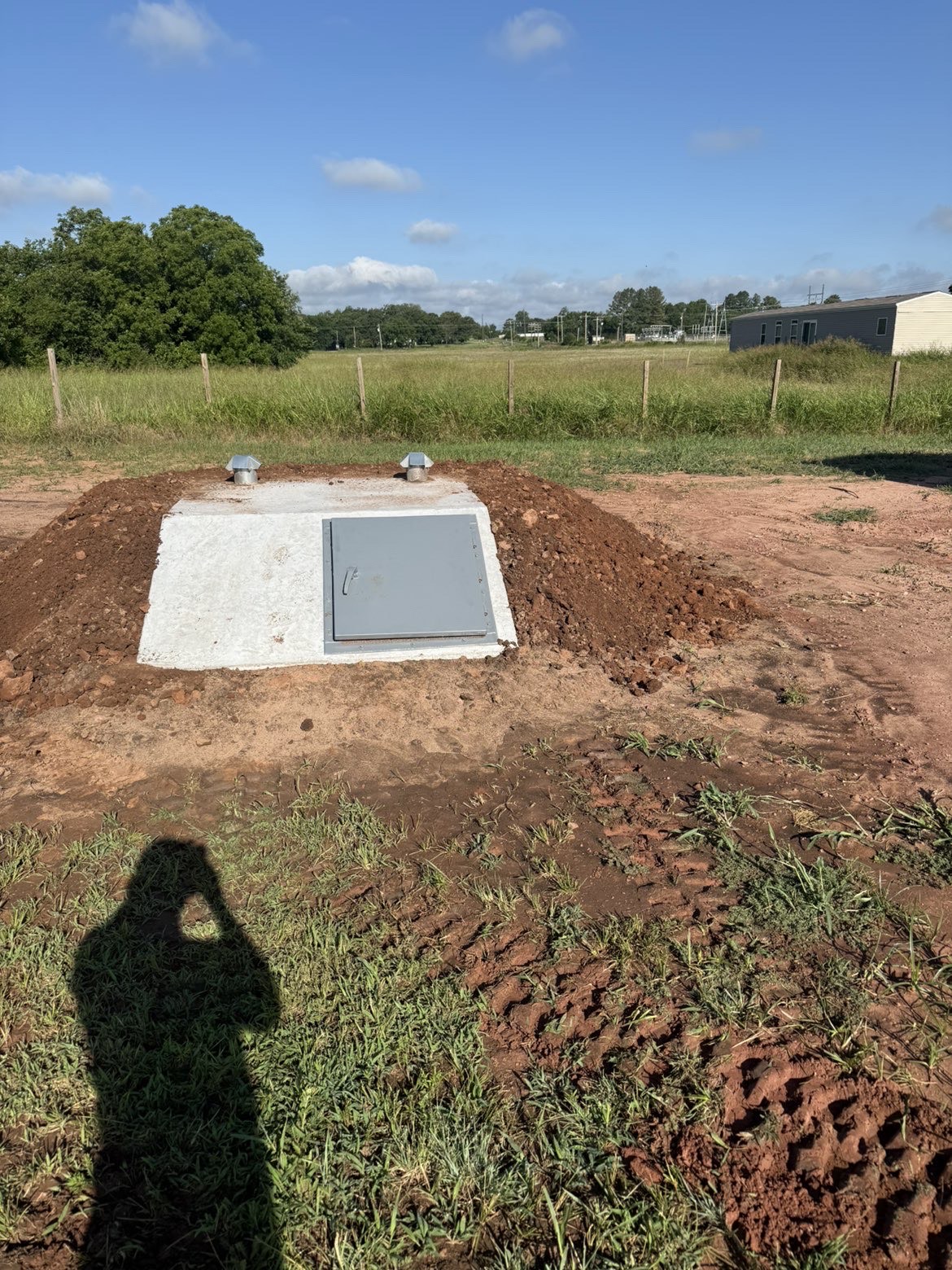 Completed concrete storm shelter with vents and access door